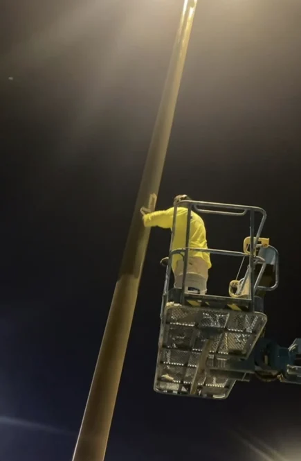 Technician working on a Costco light pole at night
