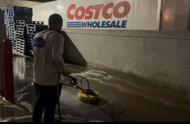 Surface-cleaning work along the Costco entrance walkway after dark