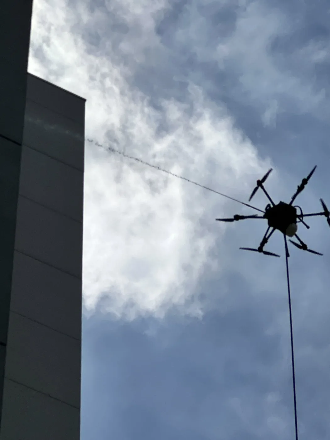 Cleaning drone and hose photographed beside a building