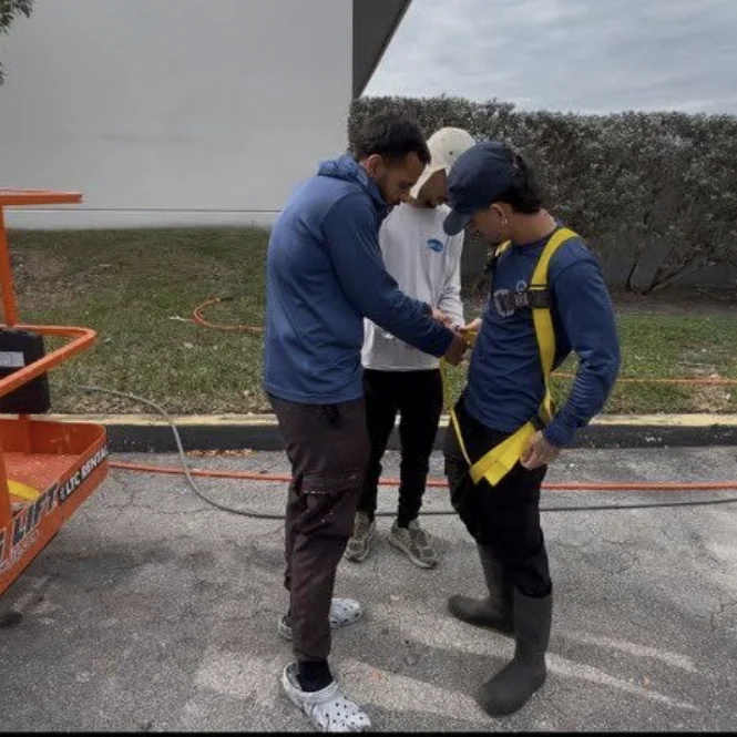 Team members checking a safety harness beside access equipment during Medley industrial work