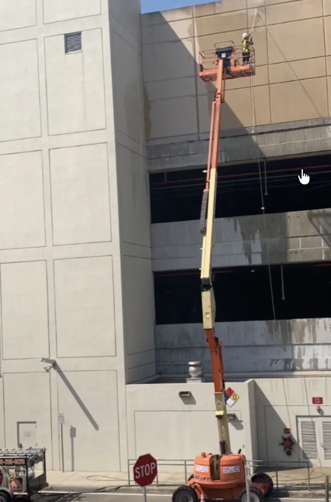 Wide view of elevated access equipment beside the airport parking structure