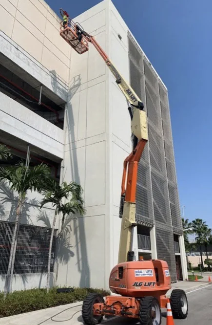 Boom lift alongside the Miami International Airport Rental Car Center facade