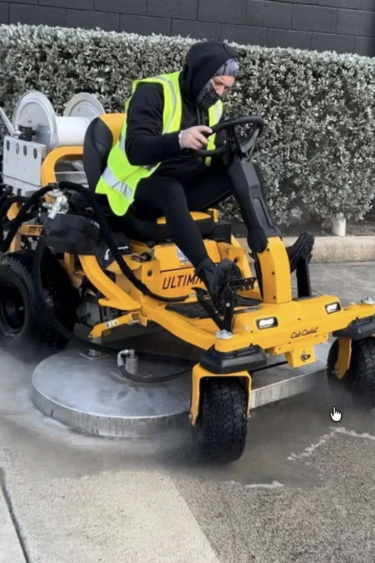 Pressure Kleen technician operating a ride-on surface cleaner