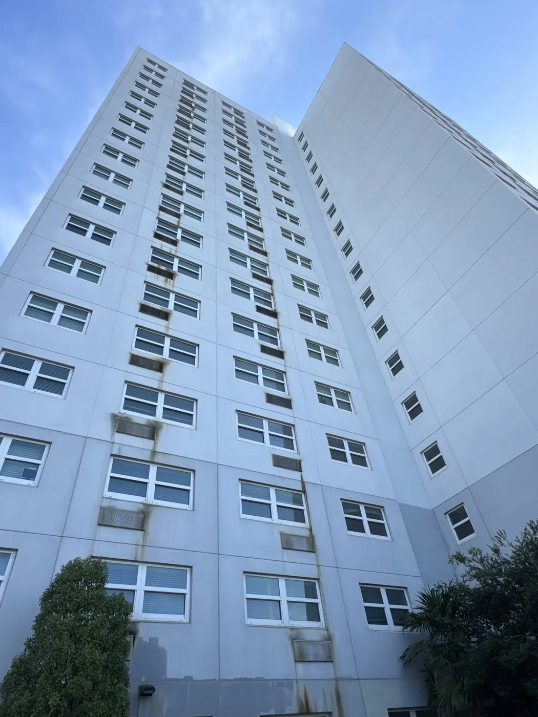 Upward view of a white high-rise exterior; not labeled as an after photo